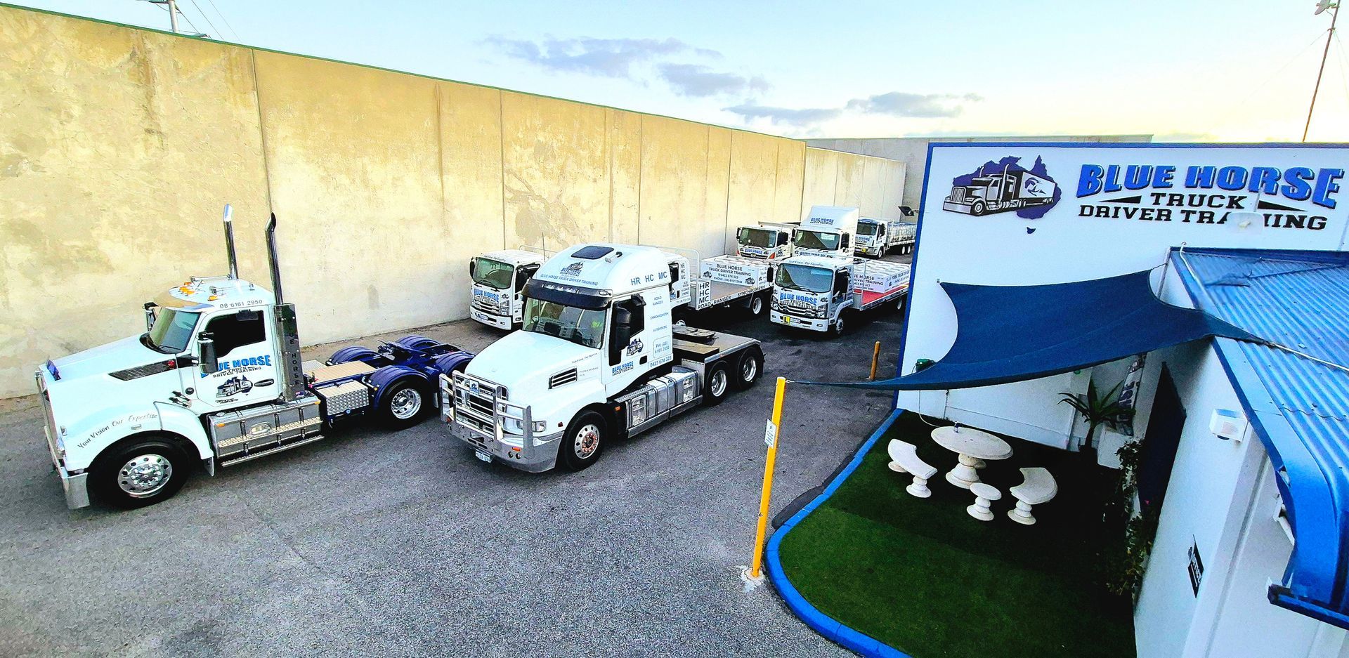Semi trucks parked in front of a Blue Horse Trucking business.