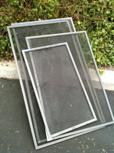 Three screens are stacked on top of each other on the ground.
