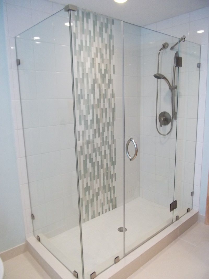 A shower stall with a glass door and a shower head.