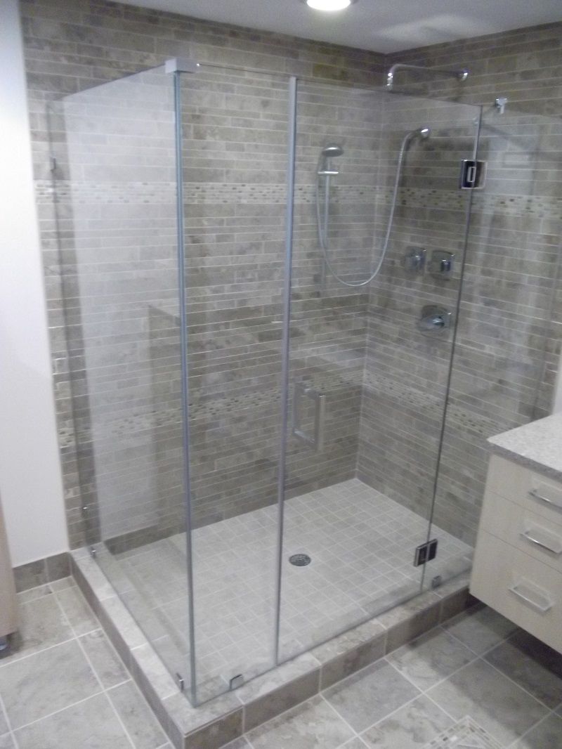 A bathroom with a walk-in shower with a glass door.
