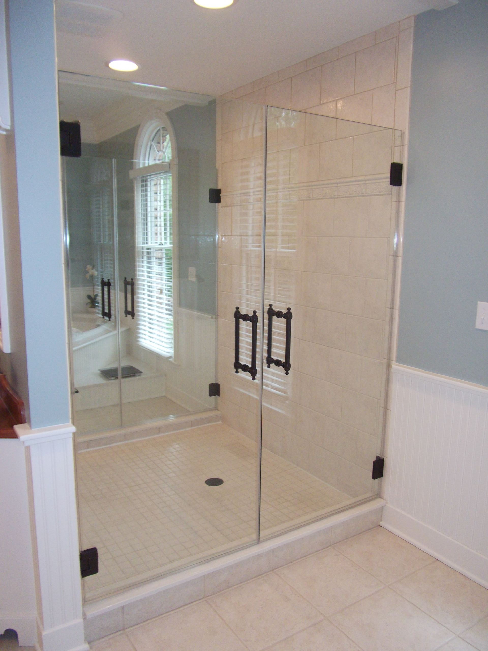 A bathroom with a walk in shower and a mirror.
