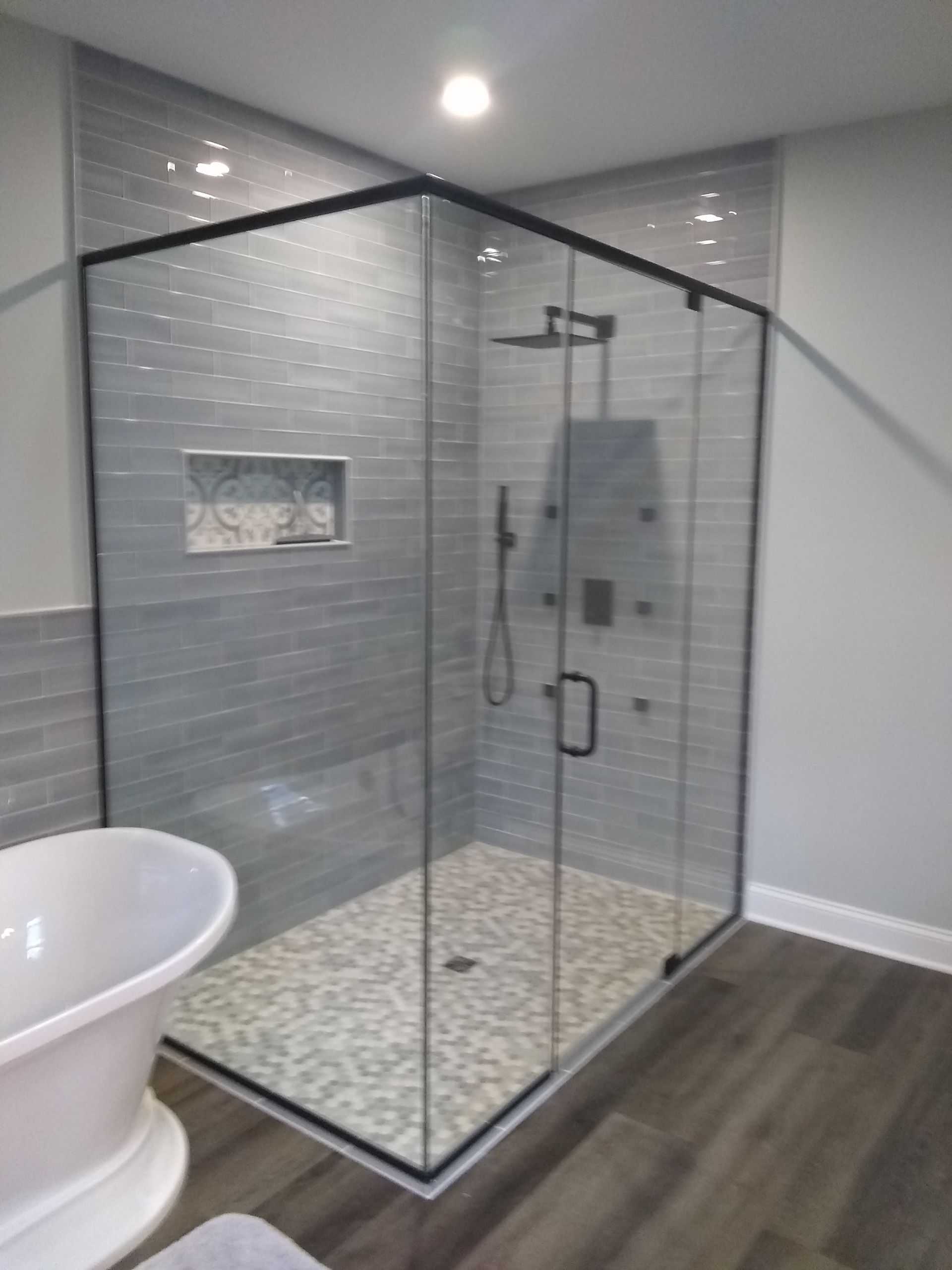 A bathroom with a walk in shower and a bathtub.