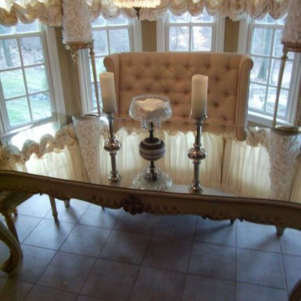 A dining room table with candles and a couch.