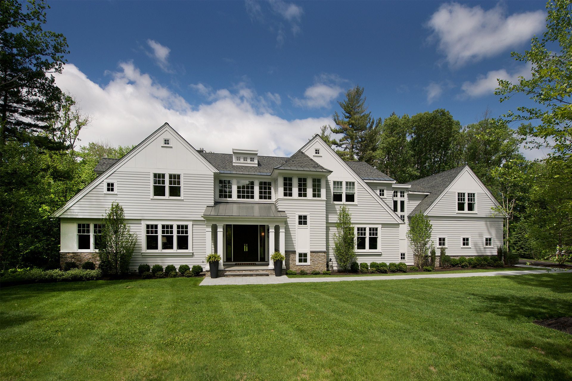 A large white house with a lush green lawn in front of it