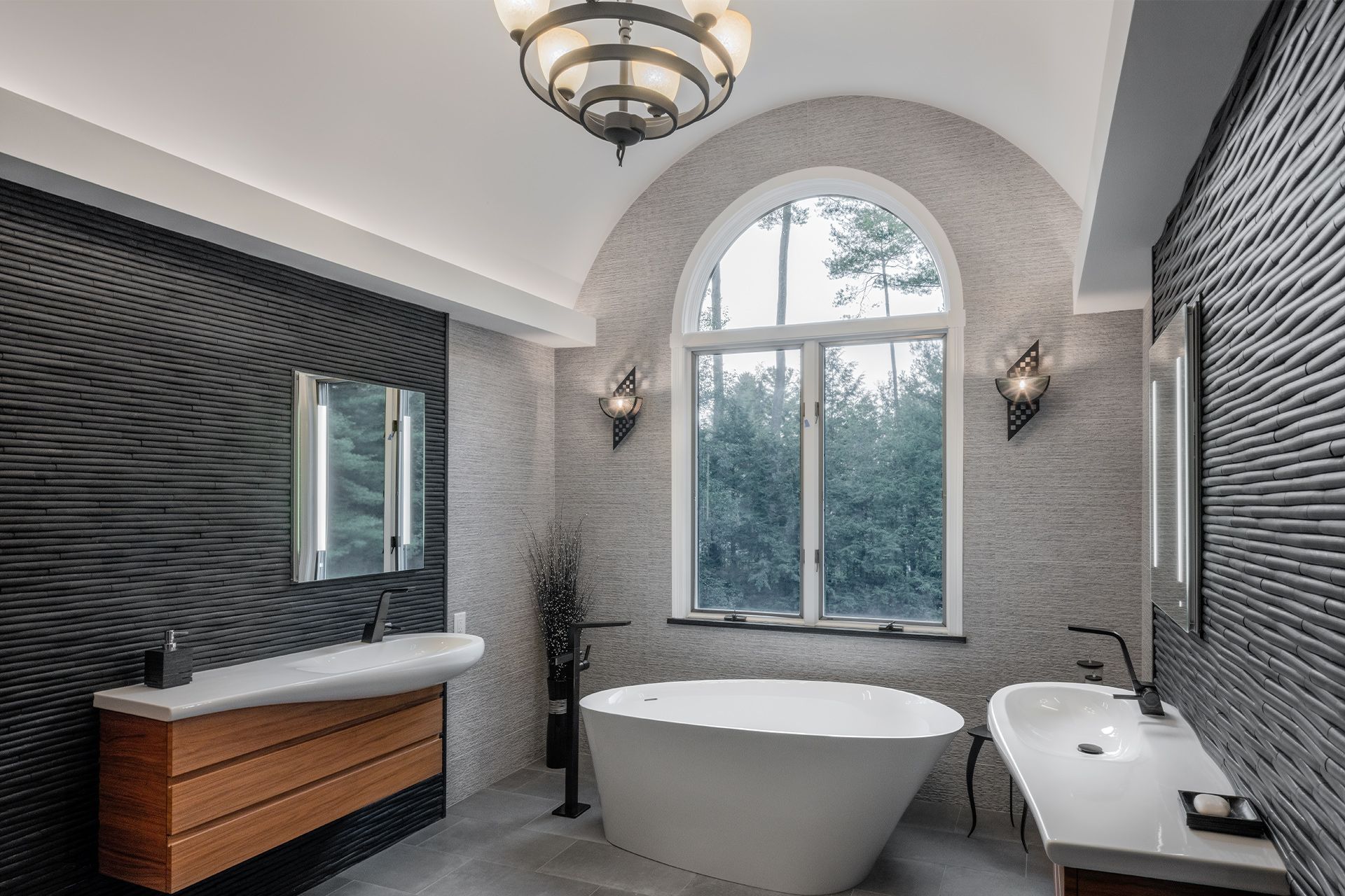 A bathroom with a tub , sink , mirror and window.