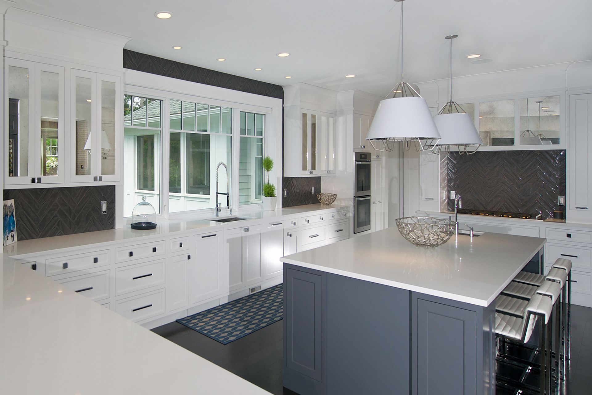 A kitchen with white cabinets and a large island in the middle.