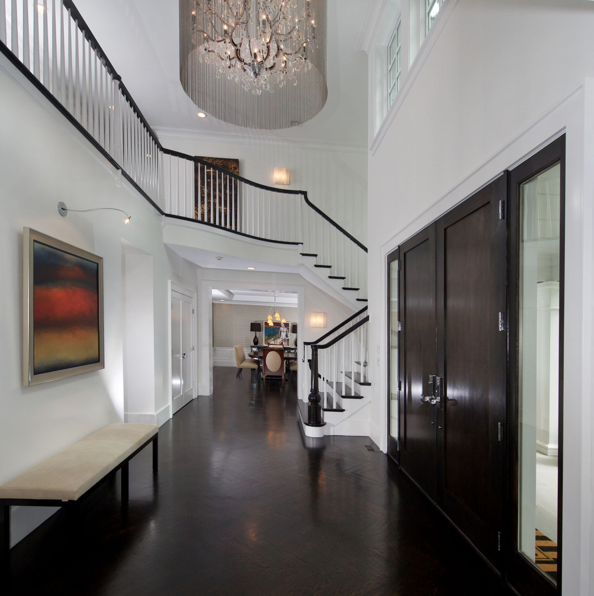 A hallway with stairs and a chandelier hanging from the ceiling