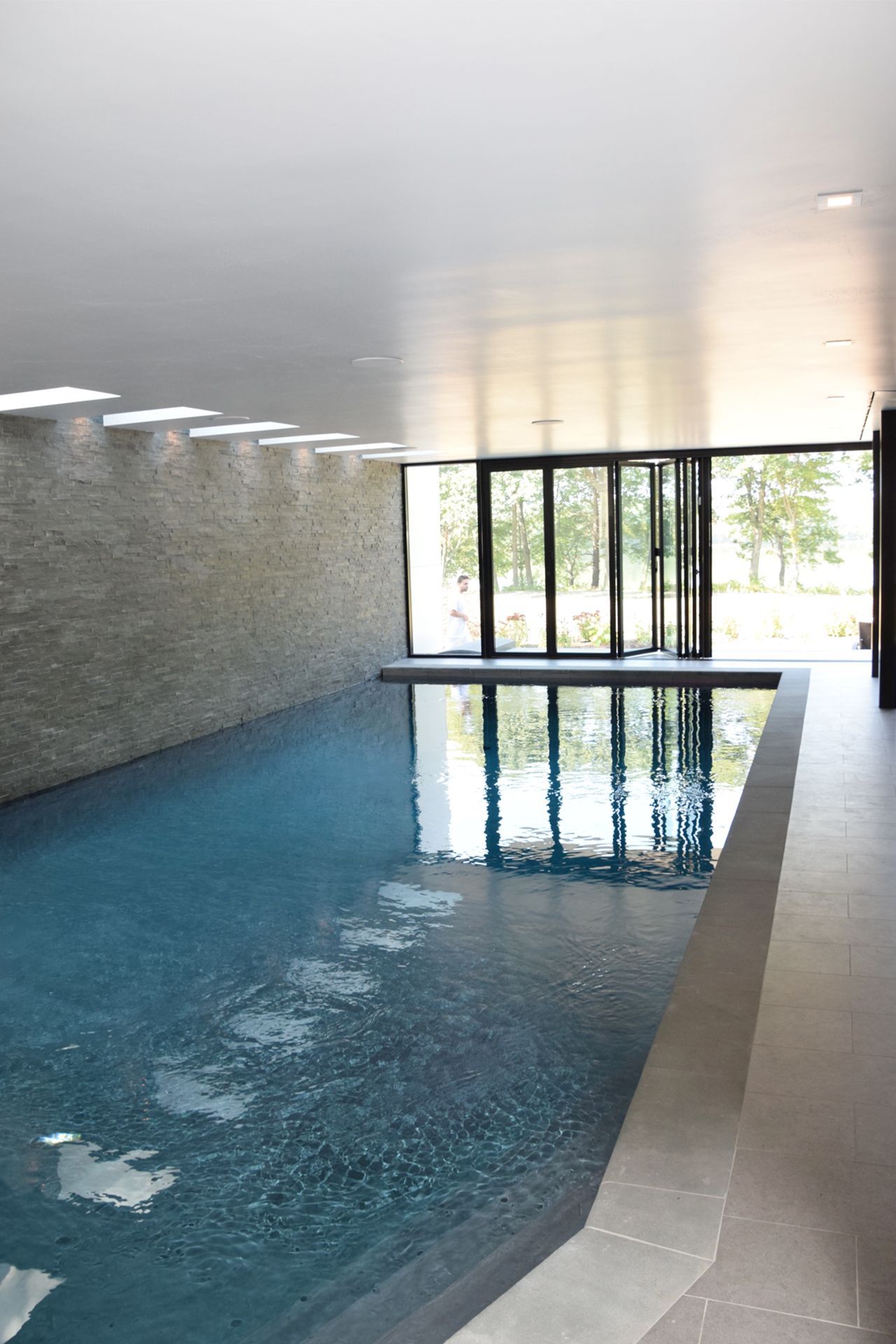 A large indoor swimming pool with a lot of windows