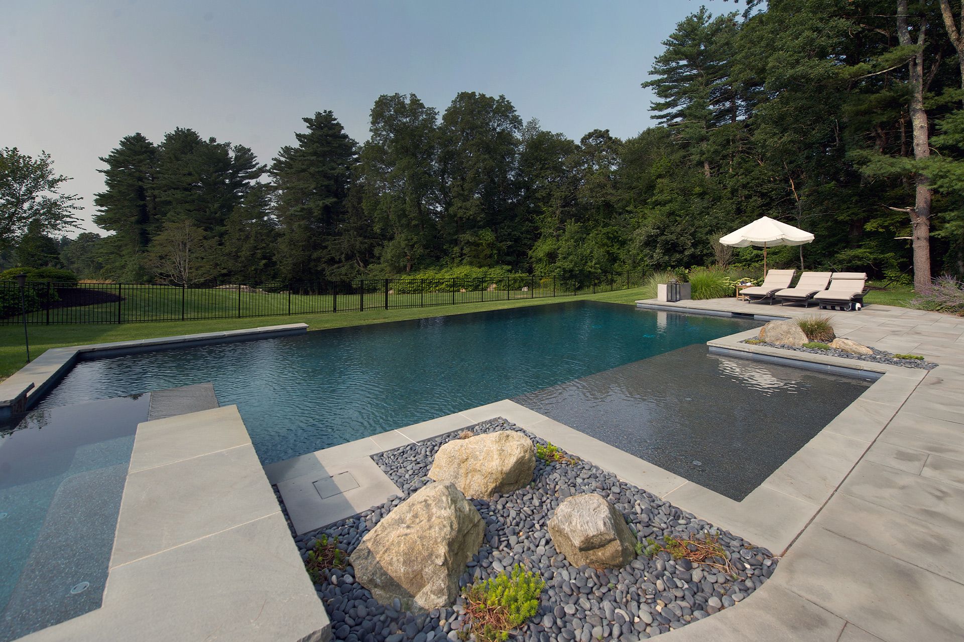 A large swimming pool surrounded by rocks and trees