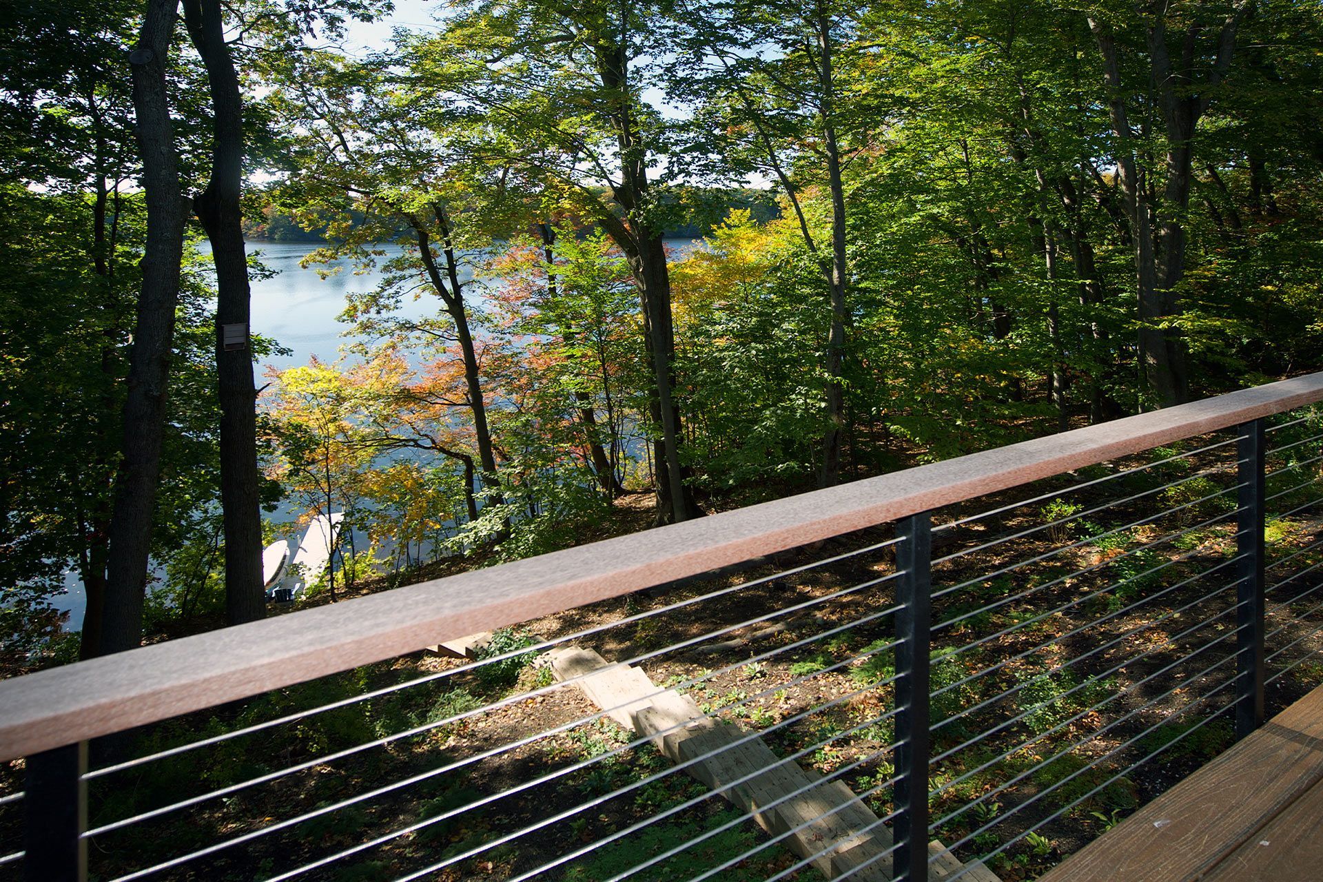 A view of a lake from a deck with trees in the background