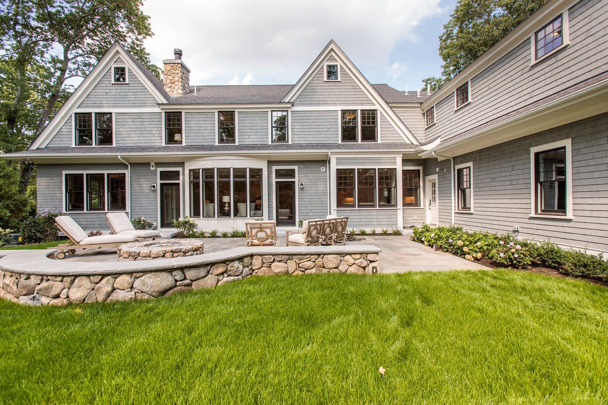 A large house with a patio and a fire pit in the backyard.