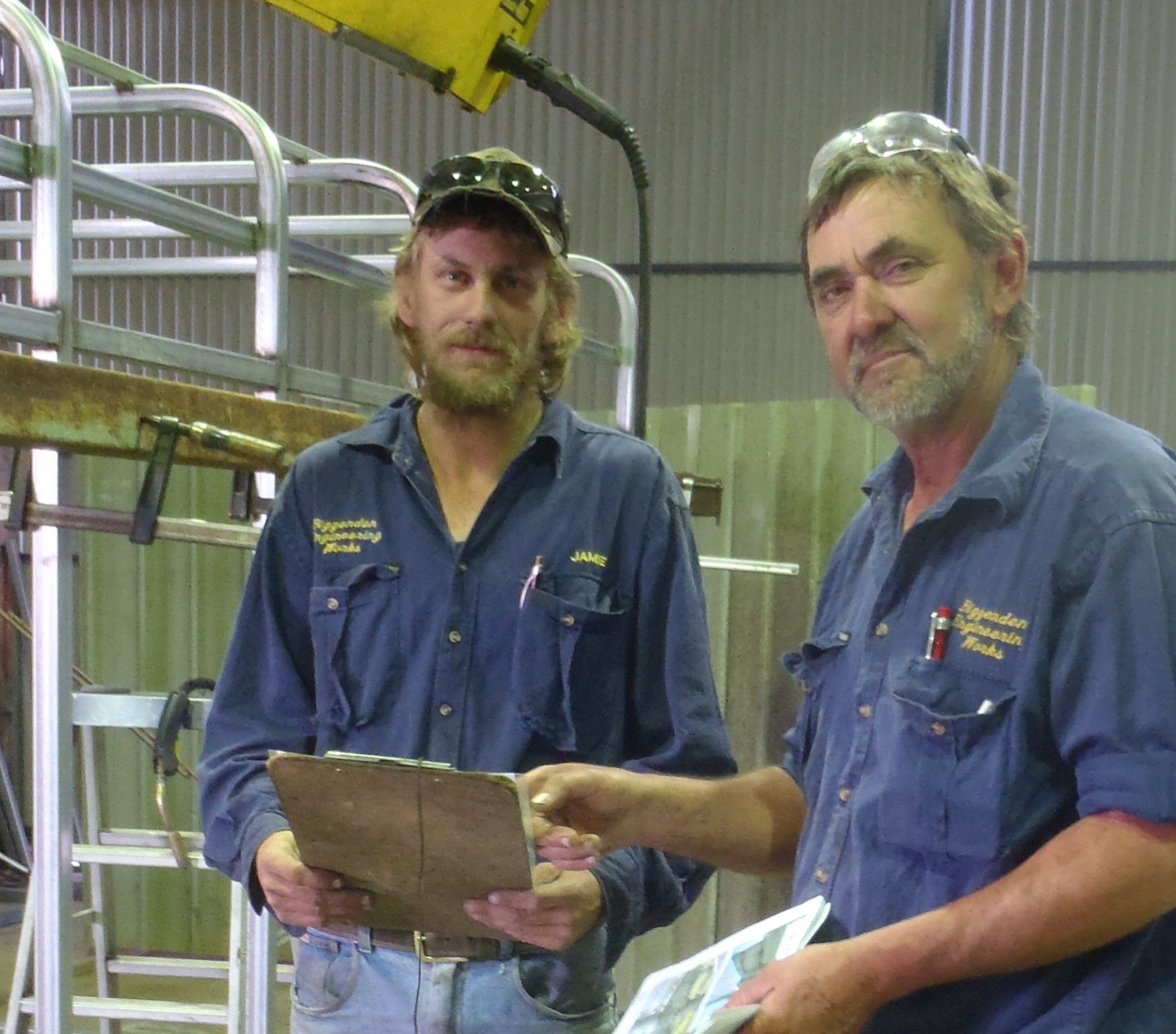Two men standing next to each other with one holding a clipboard