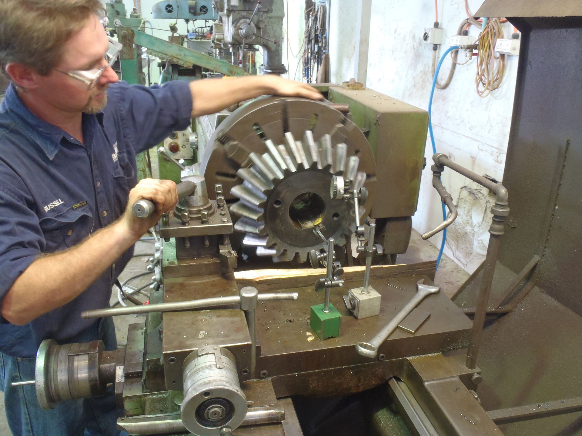 A man is working on a machine with gears on it