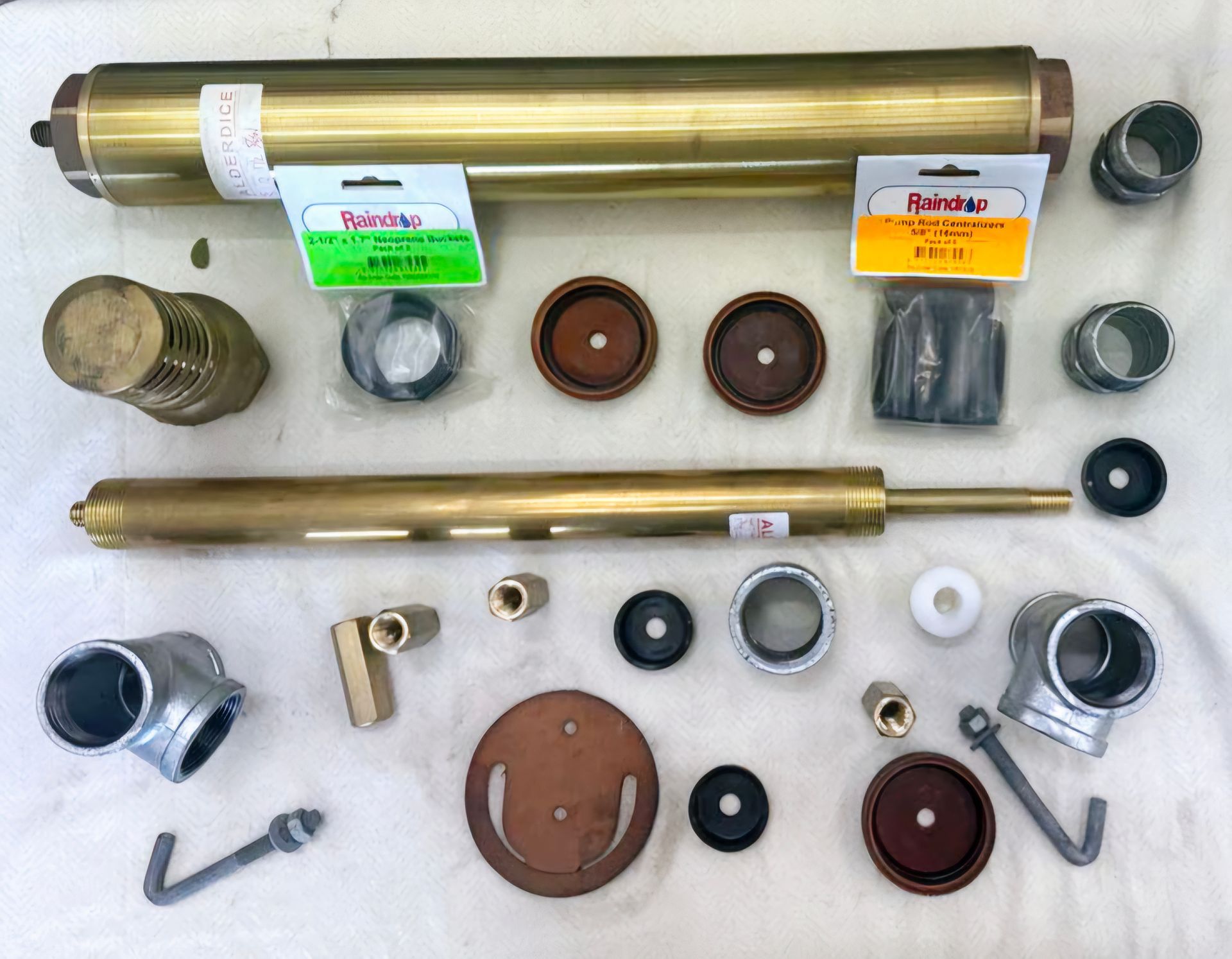 A bunch of brass and metal parts including a brass pipe