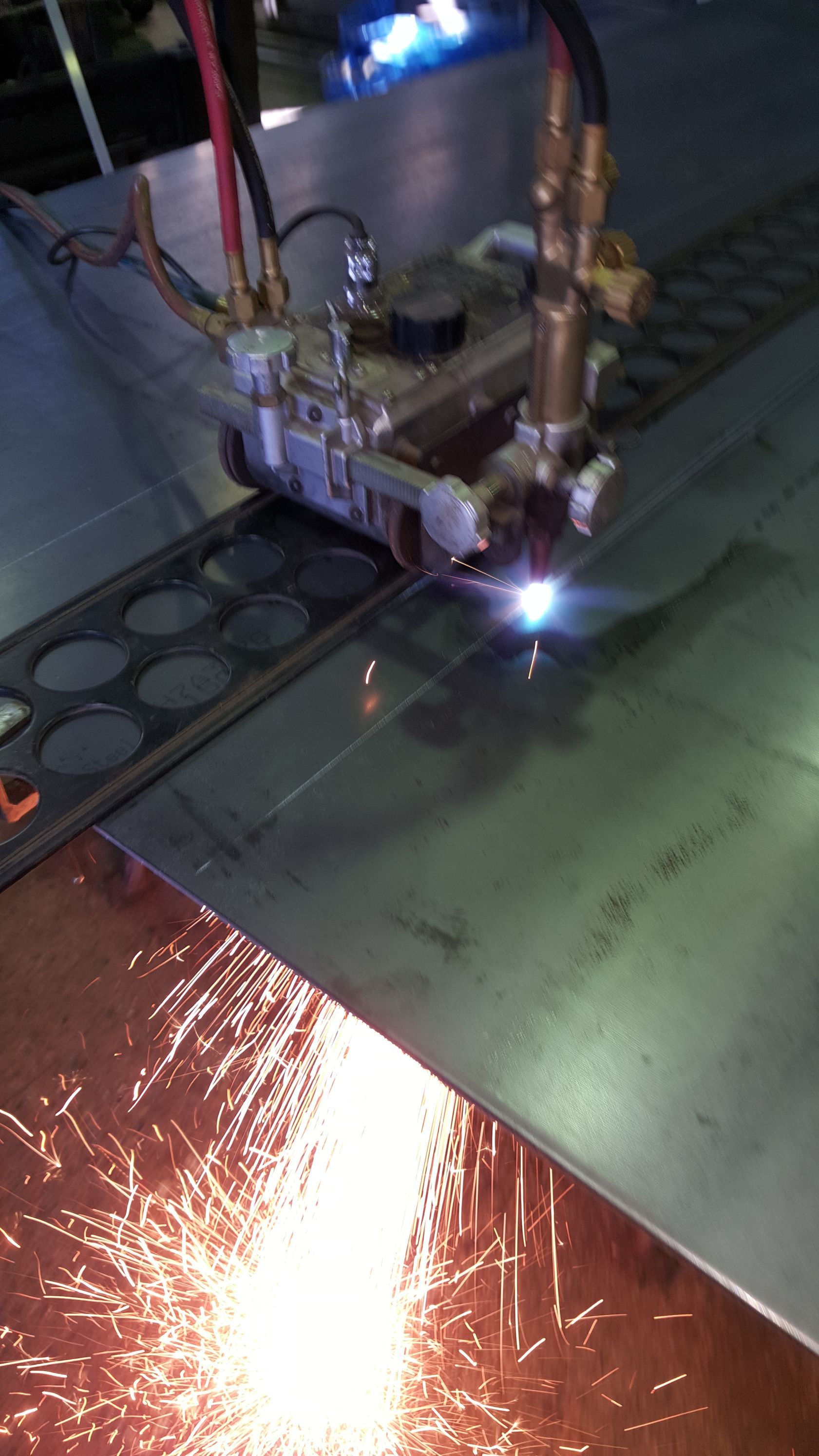 A person is welding a piece of metal in a factory.