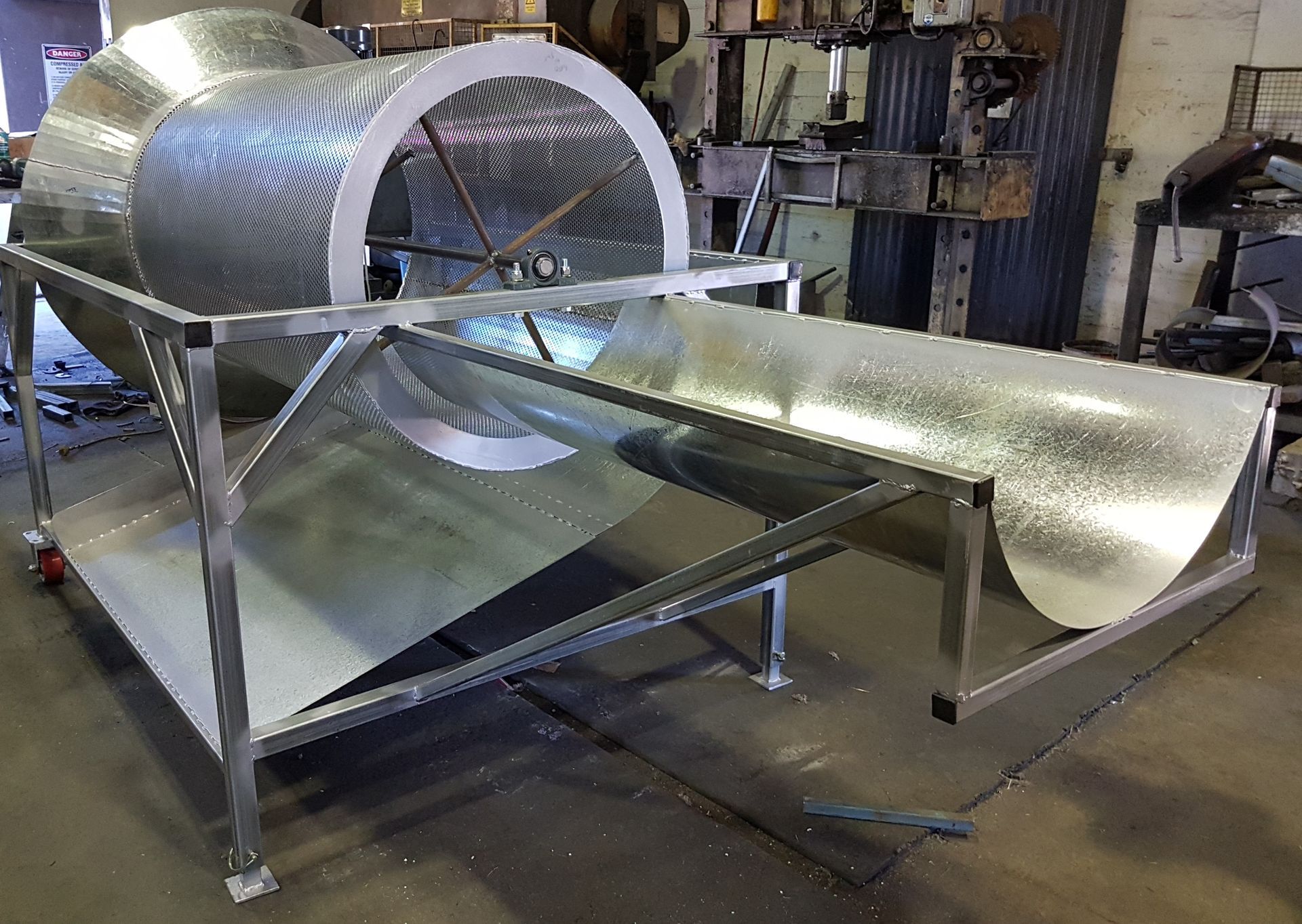 A large metal cylinder is sitting on top of a metal table.