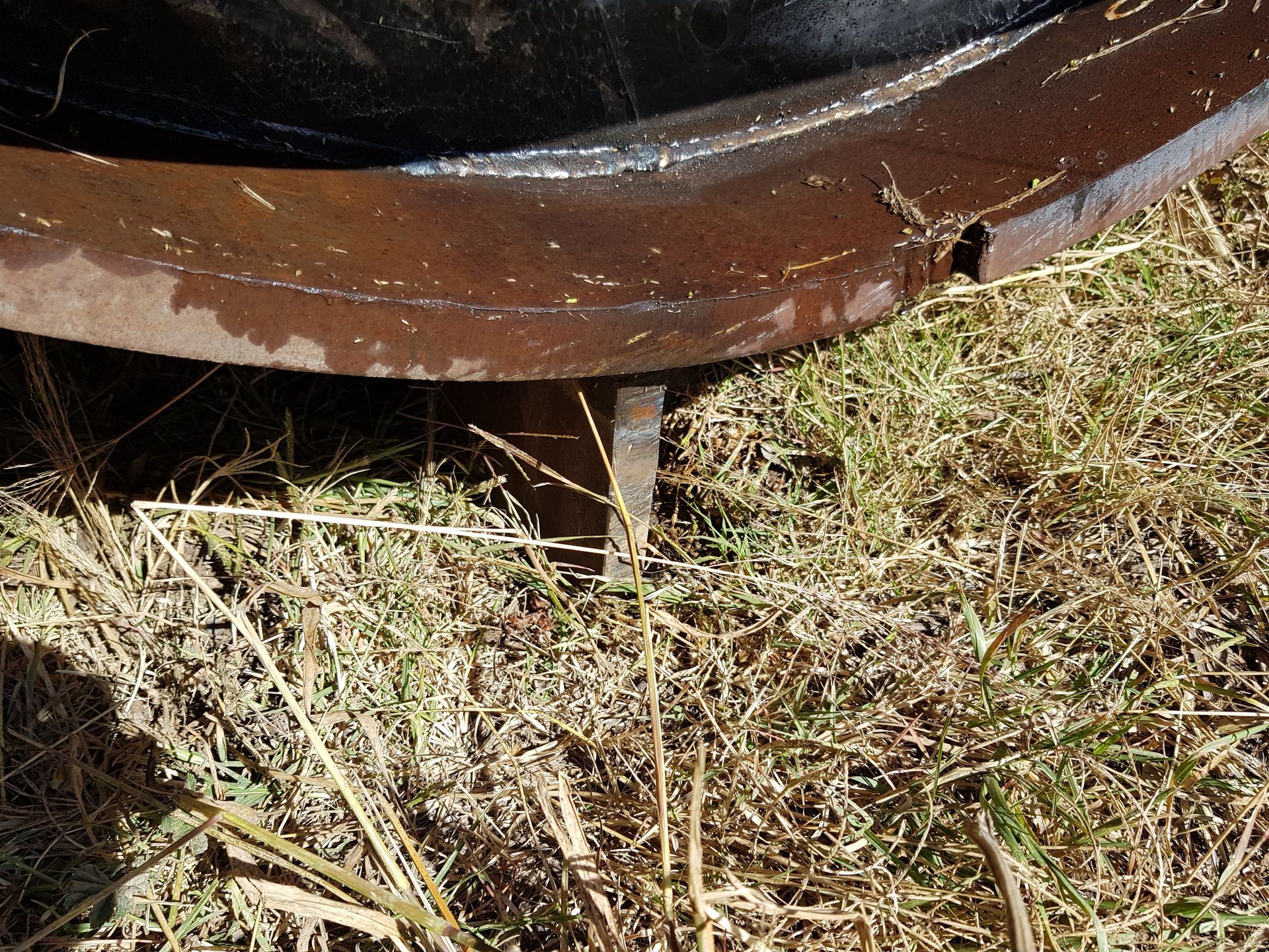 A close up of a metal object in the grass