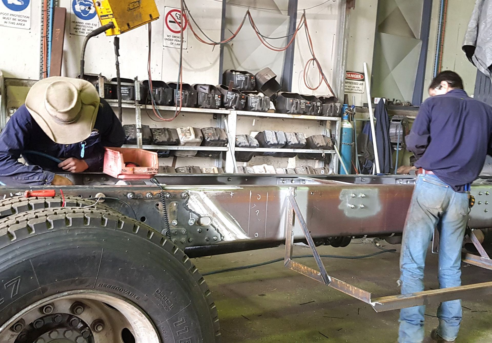 Two men are working on a truck in a garage
