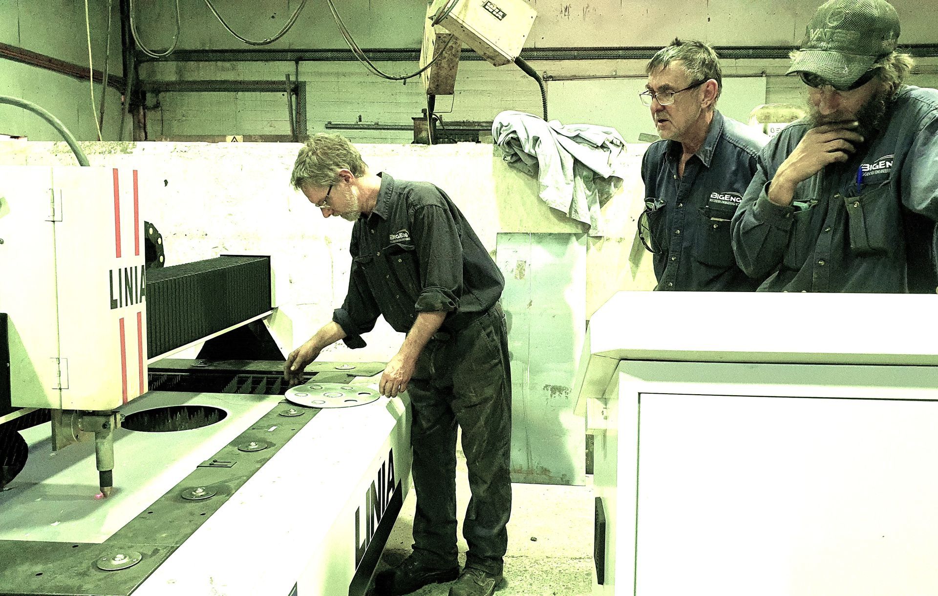 A group of men are working on a machine that says us on it