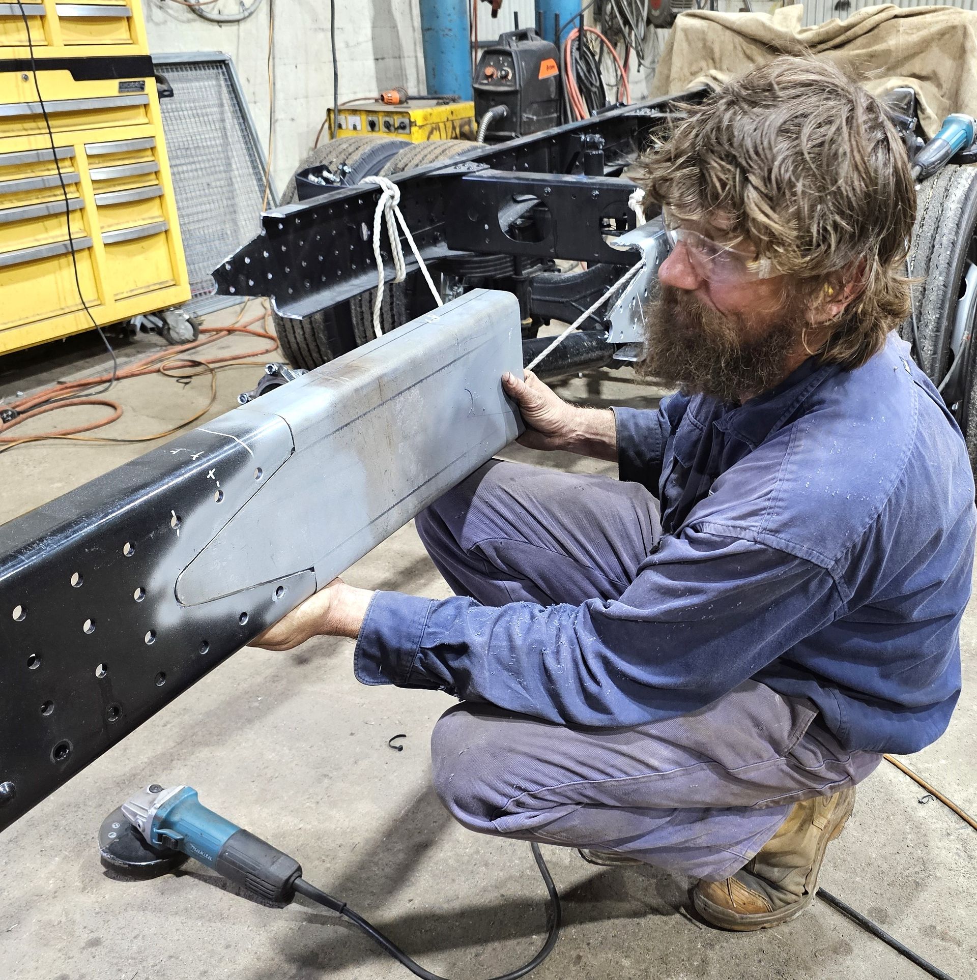 A man with a beard is working on a piece of metal