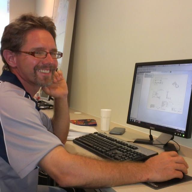 A man is sitting in front of a dell computer