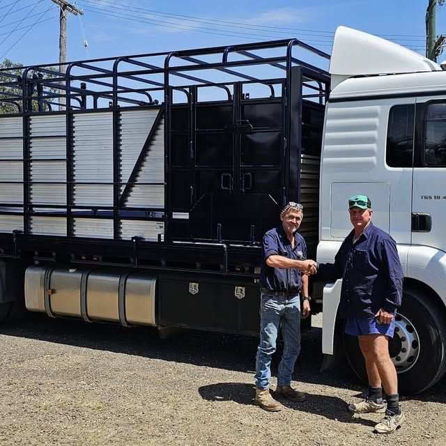 The inside of a horse trailer with a fence and a door.