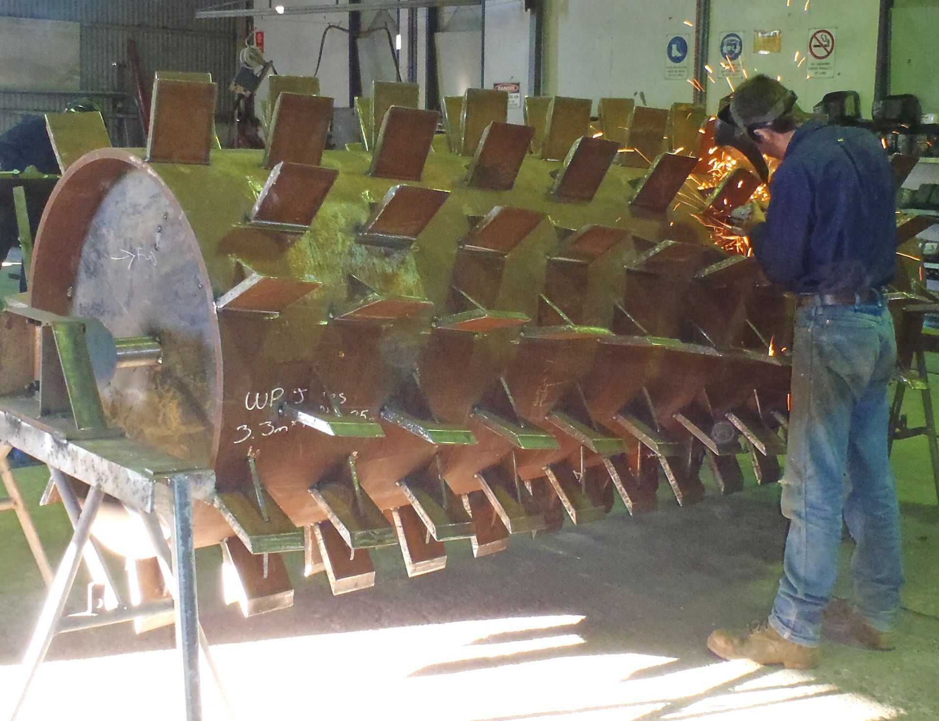 A man is working on a large piece of metal