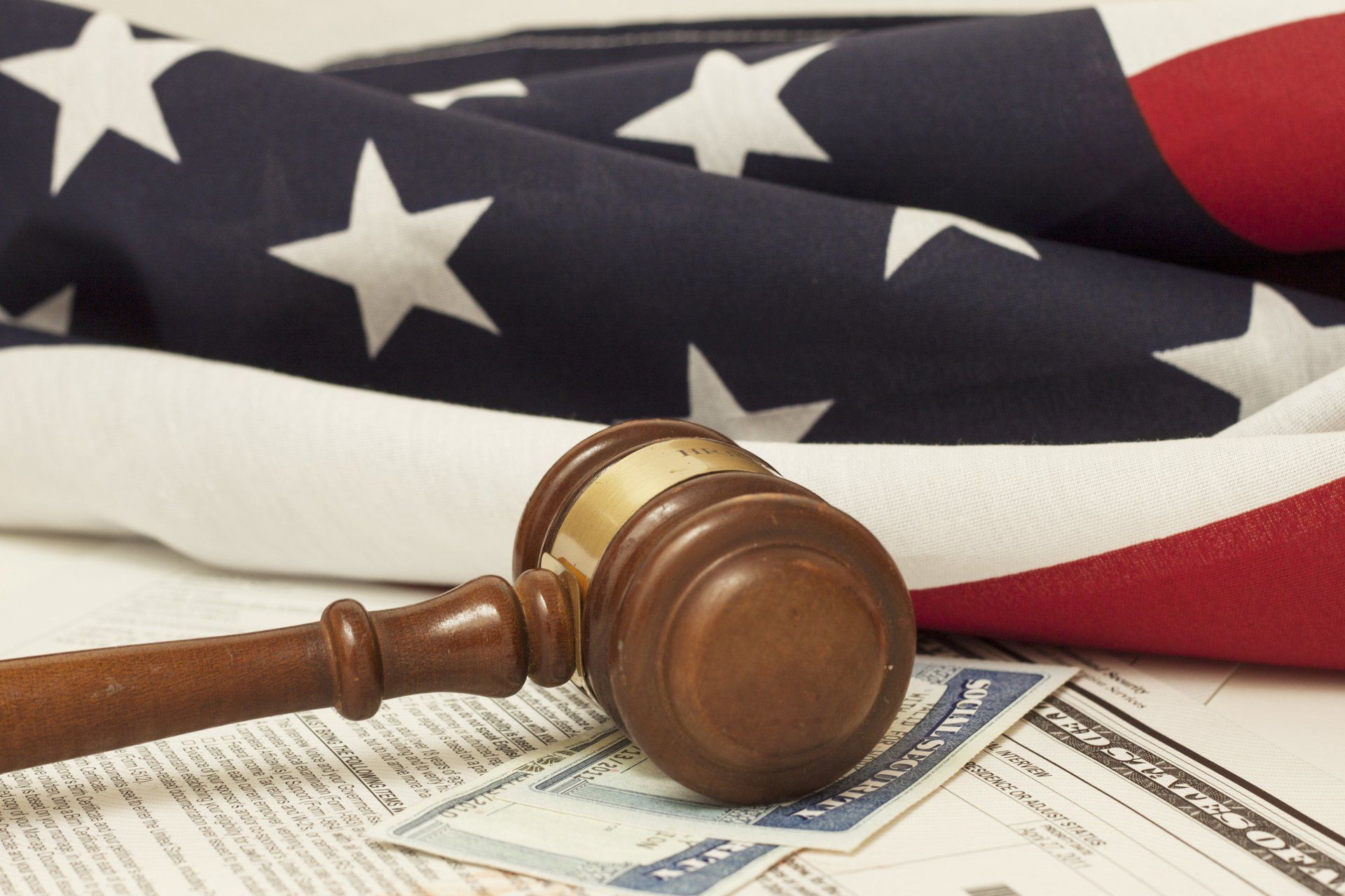 A judge 's gavel rests on a stack of papers in front of an american flag
