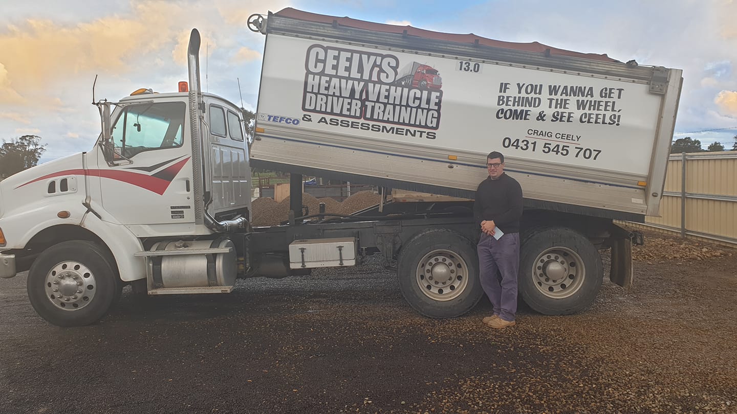 A Man in Front of a Dump Truck — Ceely's Heavy Vehicle Driver Training & Assessments In Wagga Wagga, NSW