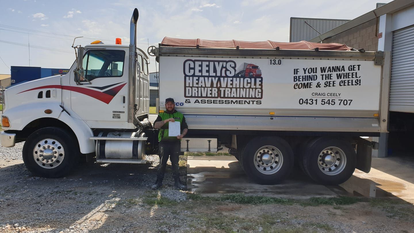 Truck Driver Holding Up Paperwork After Passing Their Driving Test — Ceely's Heavy Vehicle Driver Training & Assessments In Albury, NSW