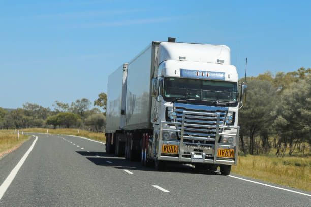 A Large White Semi Truck is Driving Down a Road — Ceely's Heavy Vehicle Driver Training & Assessments In Cowra, NSW