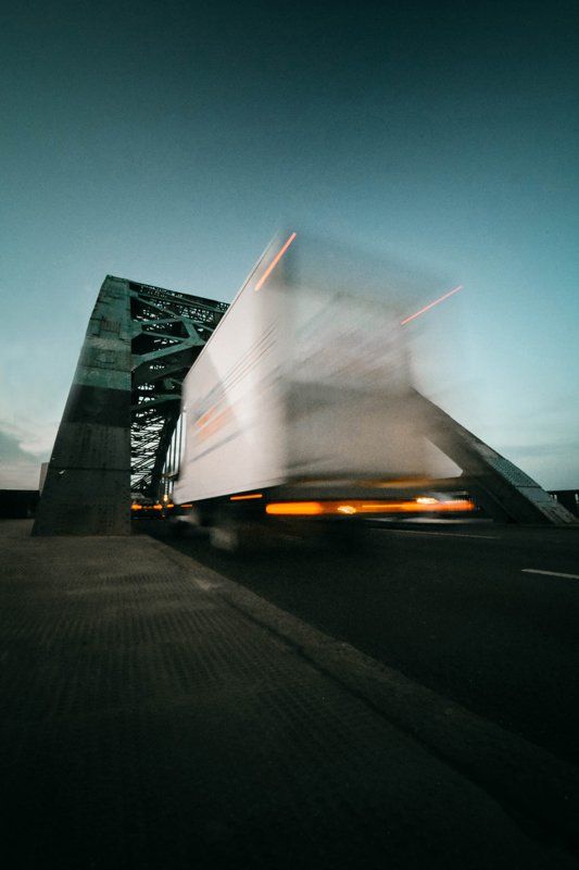 A Truck is Driving Over a Bridge at Night — Ceely's Heavy Vehicle Driver Training & Assessments In Wagga Wagga, NSW