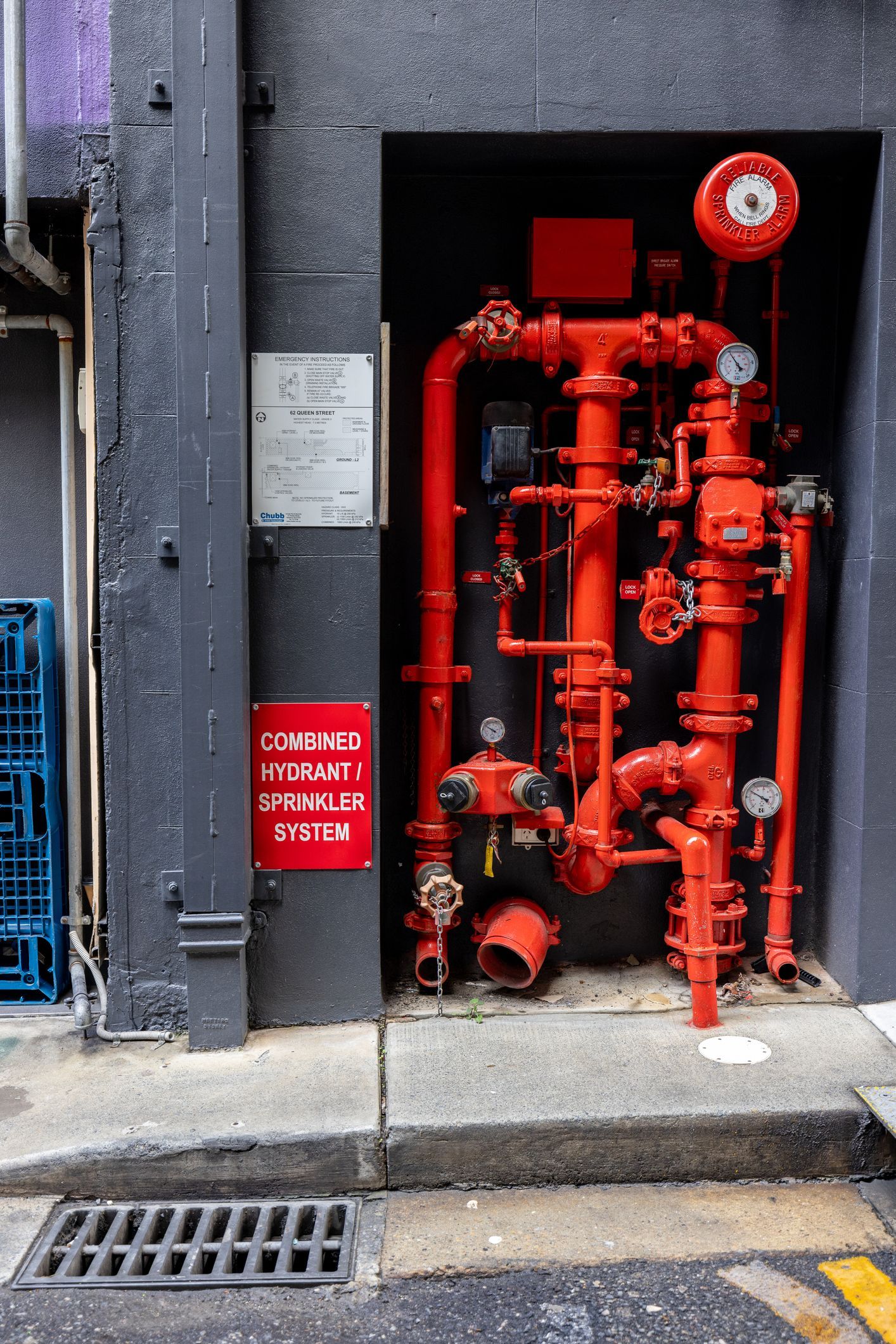 A man is standing in a room with pipes and looking at a tablet.