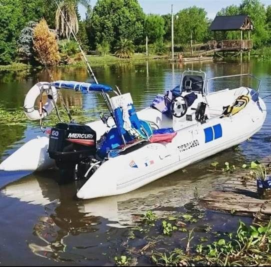 Un barco flota sobre un lago con montañas al fondo.