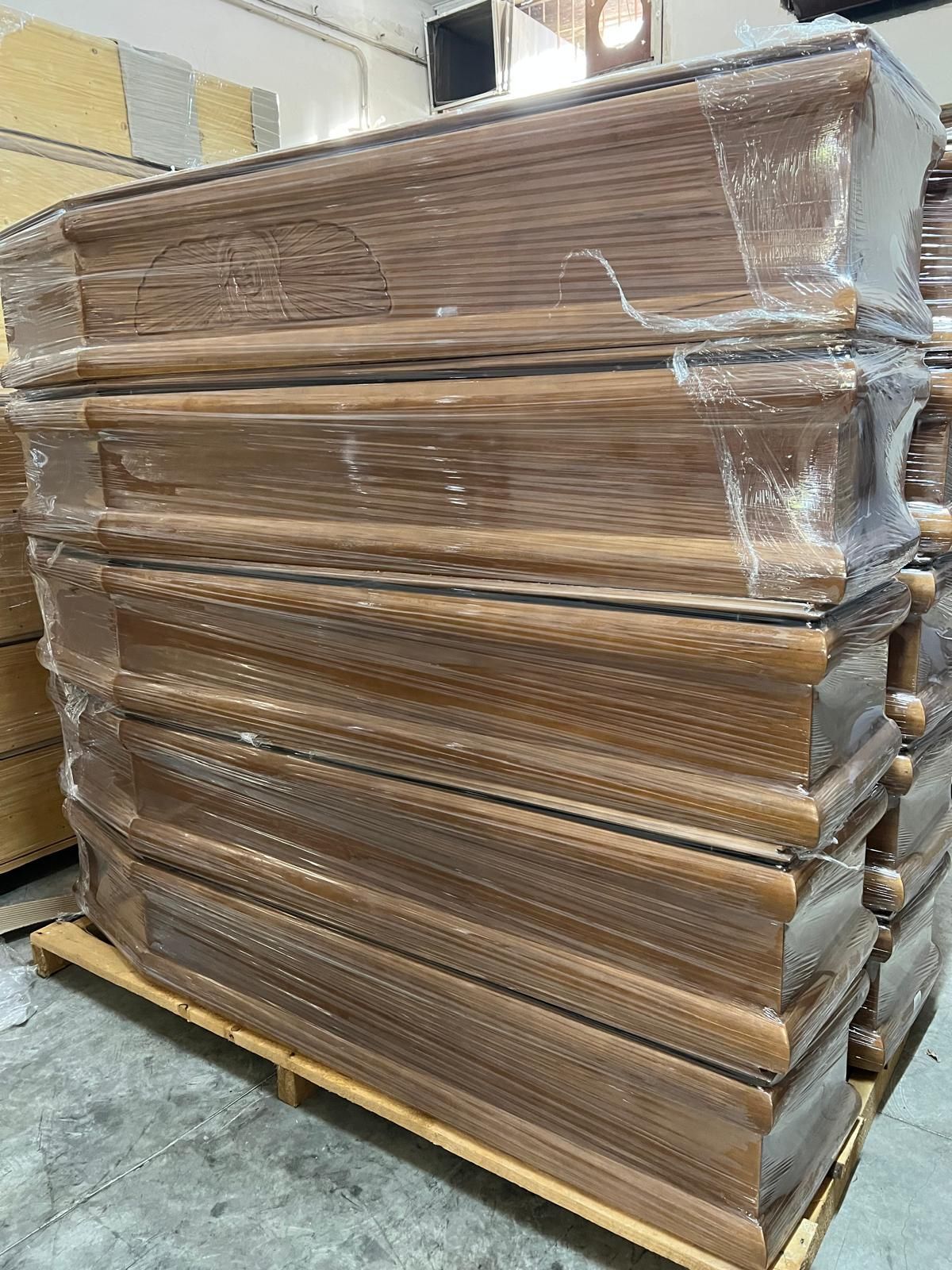 Pila di mobili in legno avvolti su un pallet.