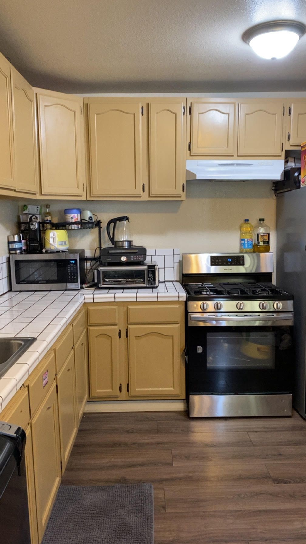 Kitchen with light brown cabinets, stainless steel appliances, and white tiled backsplash.