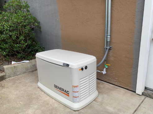 A generator is sitting on the side of a building.