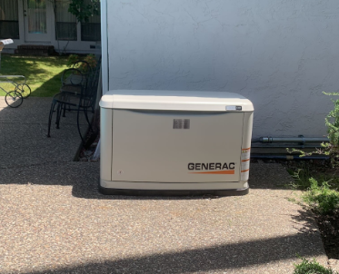 A generac generator is sitting on the side of a house.