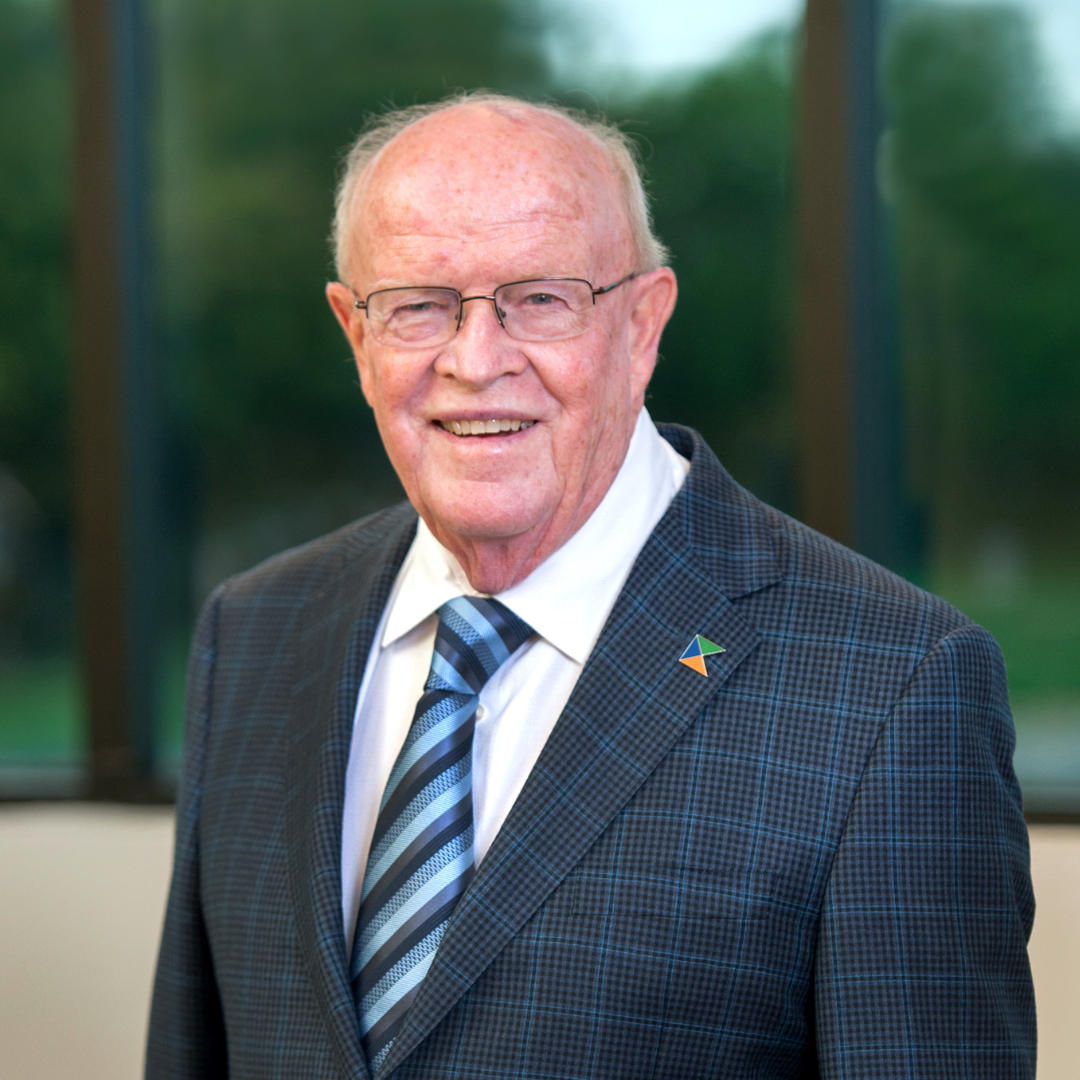 A man in a suit and tie is smiling for the camera.