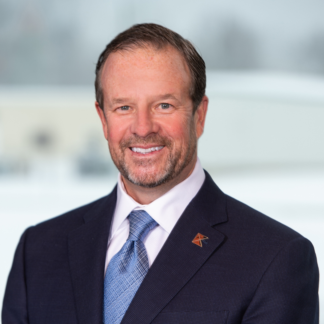 A man in a suit and tie is smiling for the camera.