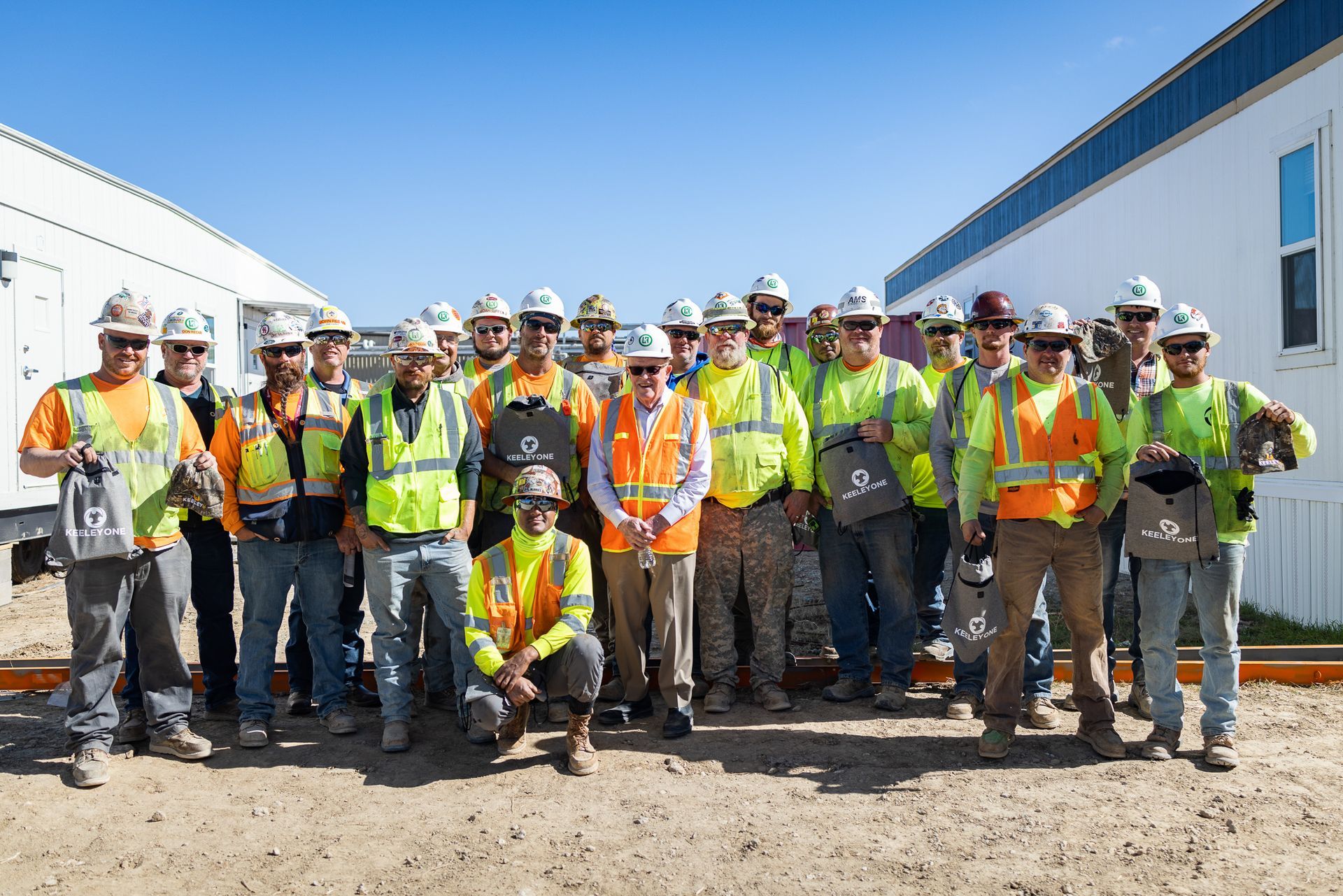 A group of construction workers are posing for a picture.