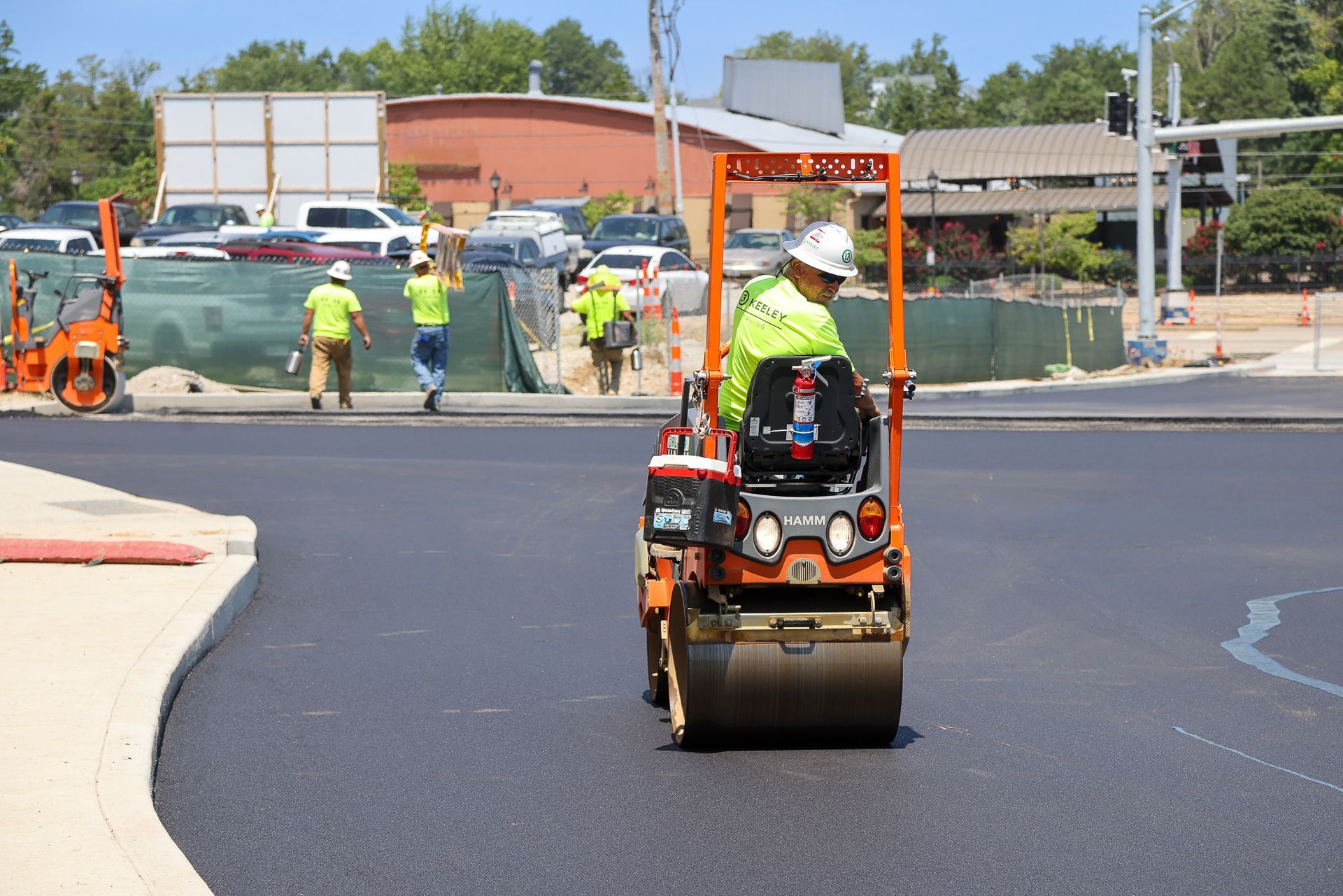 A man is driving a roller on a road.