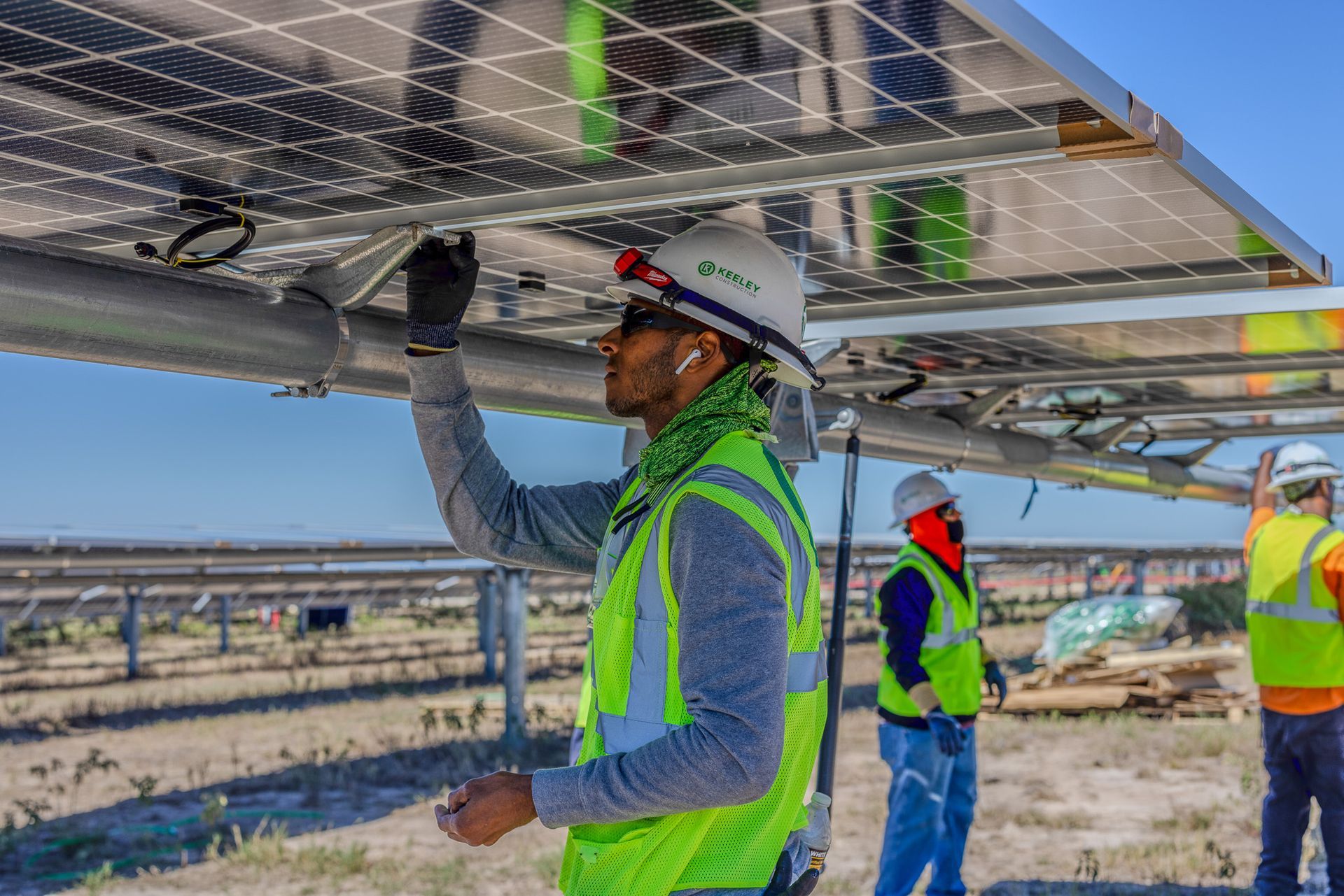 A man in a hard hat is working on a solar panel.