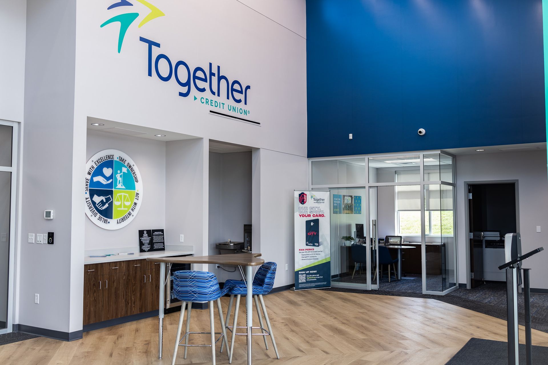 A large room with a table and chairs and a sign that says together.
