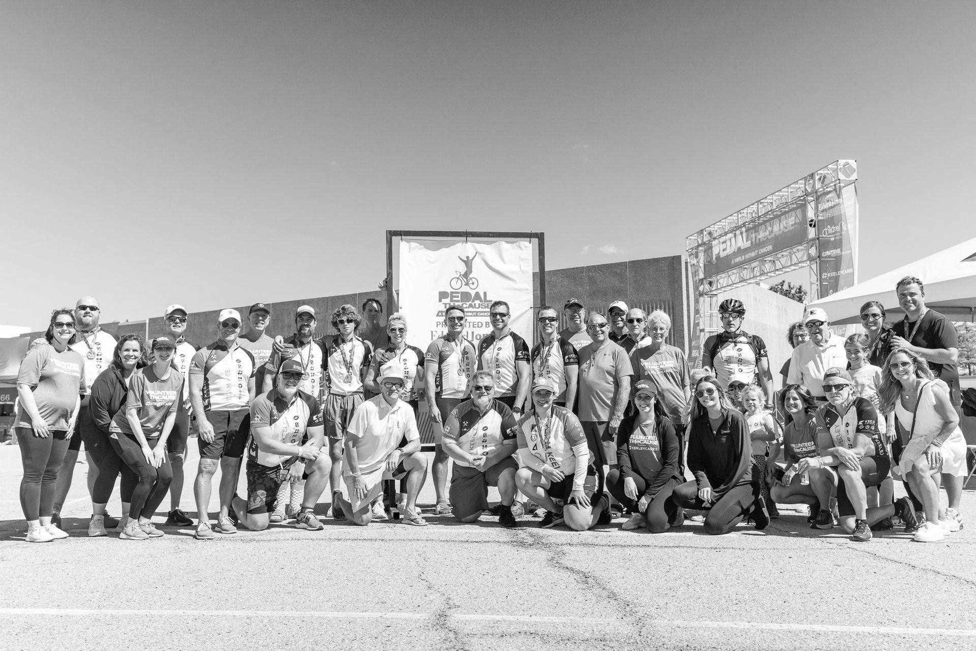 A group of people are posing for a picture in a parking lot.