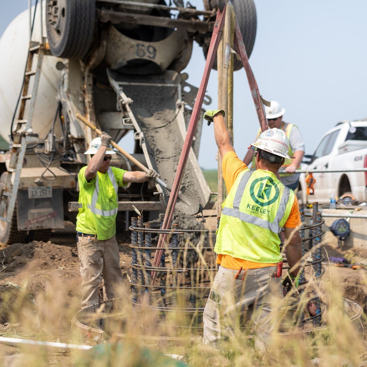 A group of construction workers wearing safety vests and hard hats