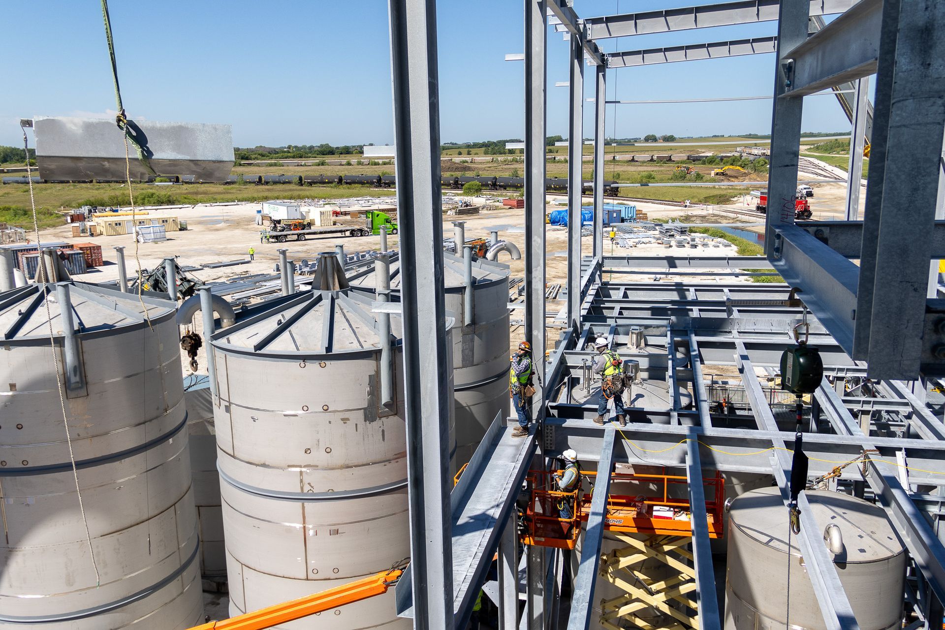 A row of stainless steel tanks are being built in a factory.