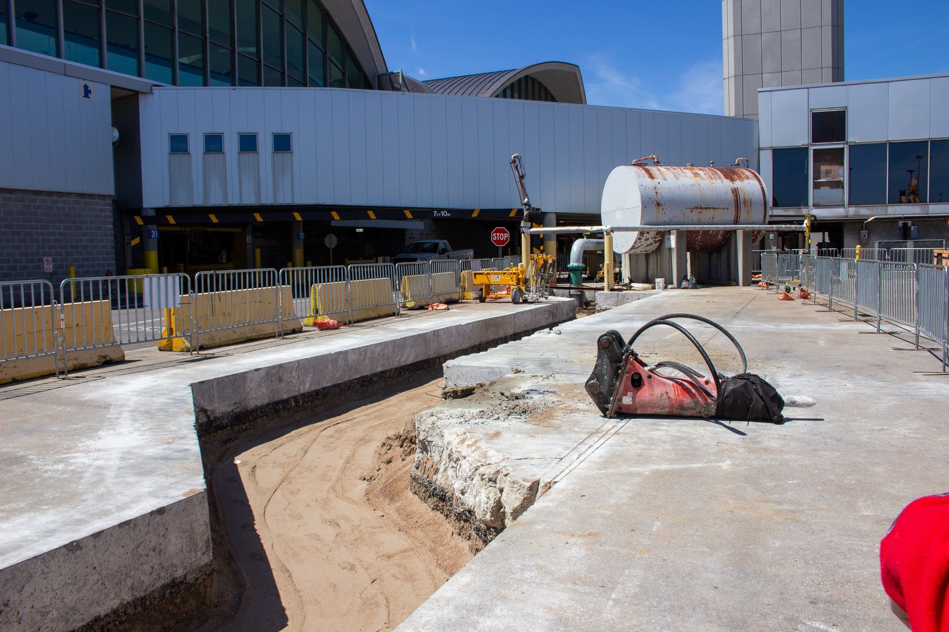 A person is laying on the ground in front of a building under construction.