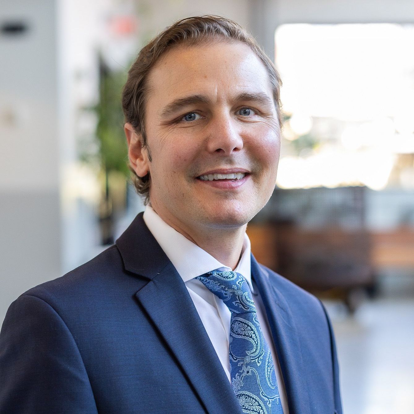 A man in a suit and tie is smiling for the camera.