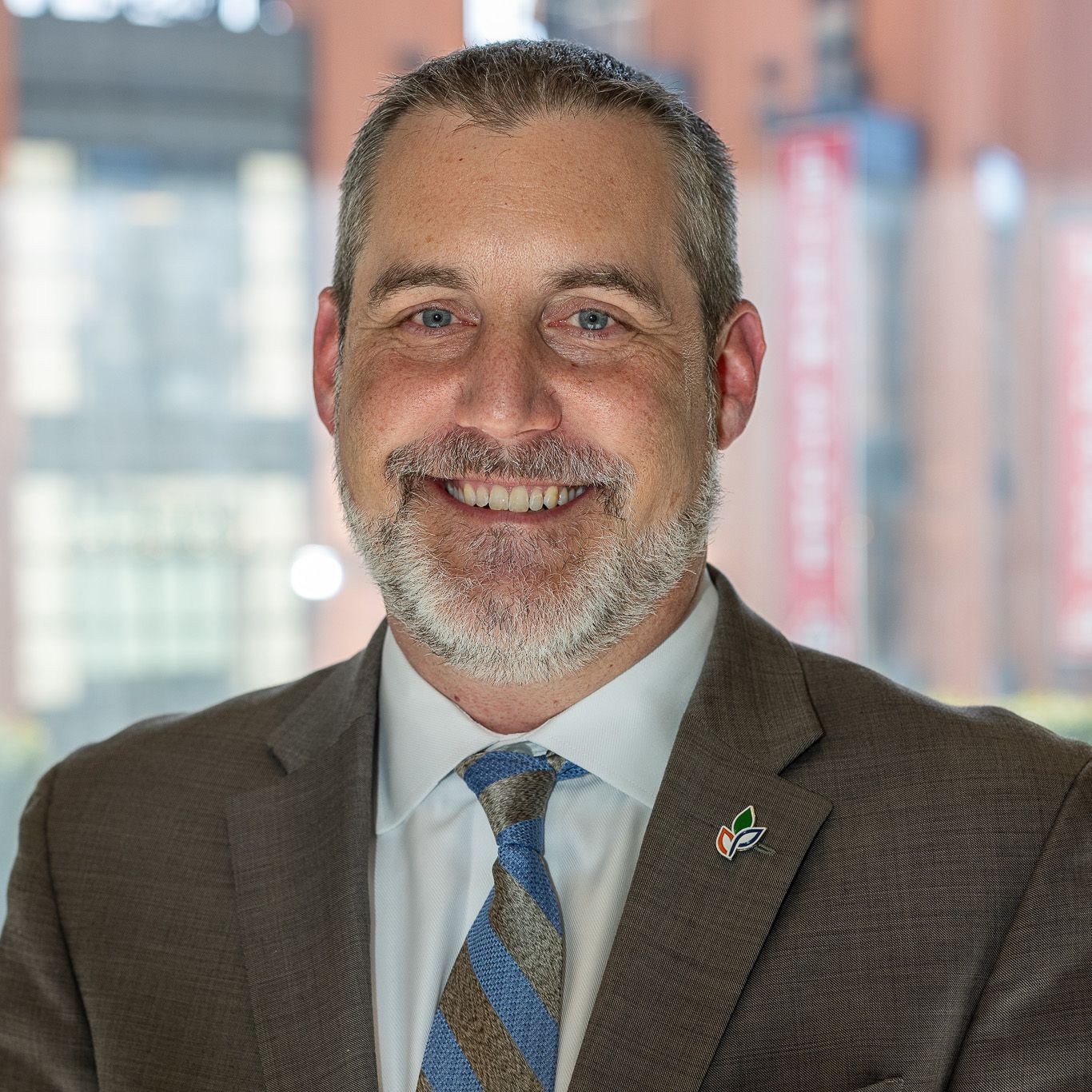 A man in a suit and tie is smiling for the camera.